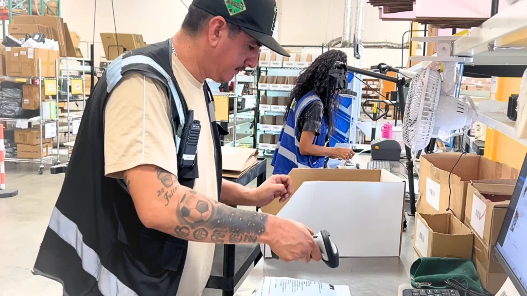 Warehouse worker scanning a barcode on a box during order fulfillment